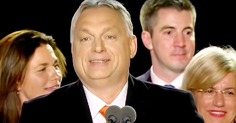 Orbán Viktor Varga Judit, Kocsis Máté és Máger Andrea társaságában beszédet tart. A miniszterelnökön fekete zakó, fehér ing és narancssárga nyakkendő van.