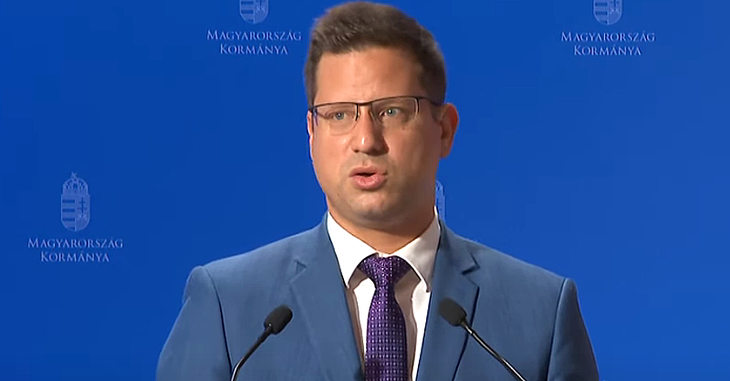 Gulyás Gergely kancelláriaminiszter kék zakóban, lila nyakkendőben, fehér ingben és szemüvegben beszél a mikrofonba a kormányinfón.