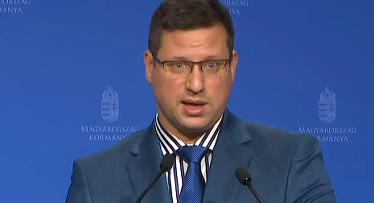 gulyás gergely kormányinfó szürke öltöny szemüvegben beszél