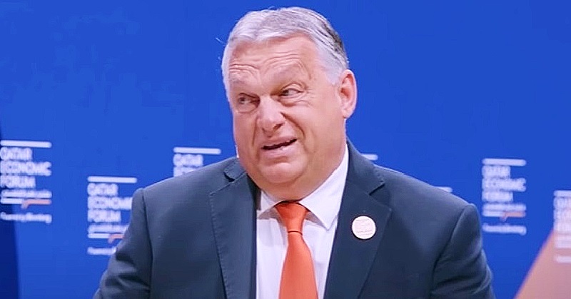 Orbán Viktor narancssárga nyakkendőben kék háttér előtt meglepődik.