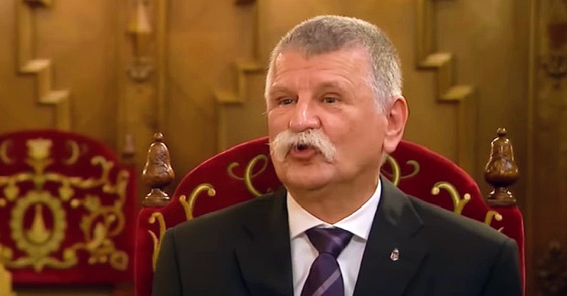 Kövér László bajszosan, rövid hajjal, fekete zakóban, fehér ingben, lila nyakkendőben, magyar címeres kitűzővel beszél.