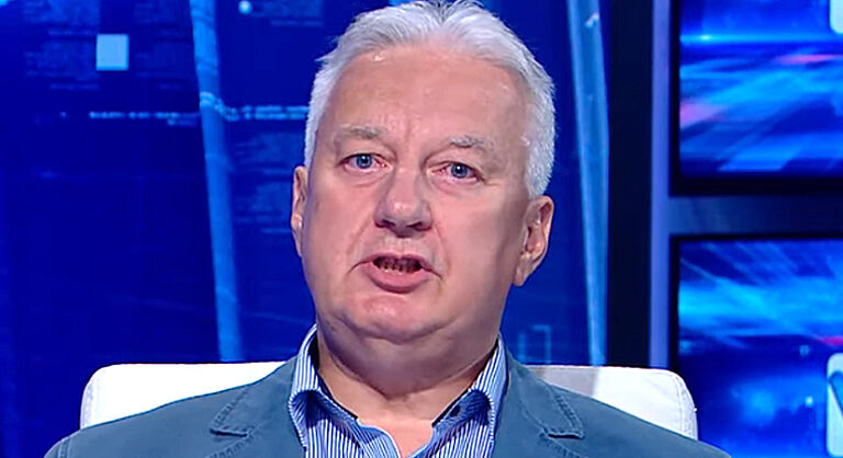 Semjén Zsolt kék öltönyben, ingben, stúdióban