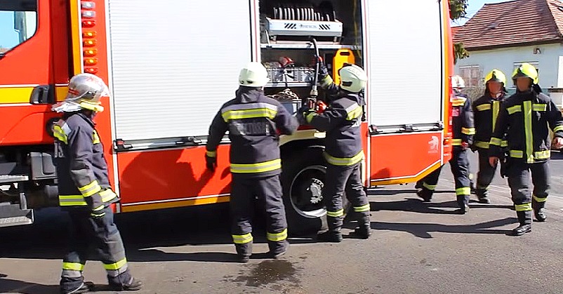 Tűzoltók egy tűzoltóautónál