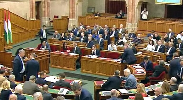 Képviselők a parlamentben vitáznak