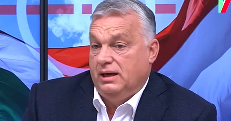 Orbán Viktor színes háttér előtt sötét öltönyben beszél
