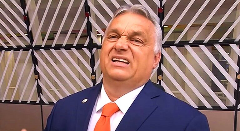 orbán viktor kék öltönyben narancssárga nyakkendőben furcsa arcot vág