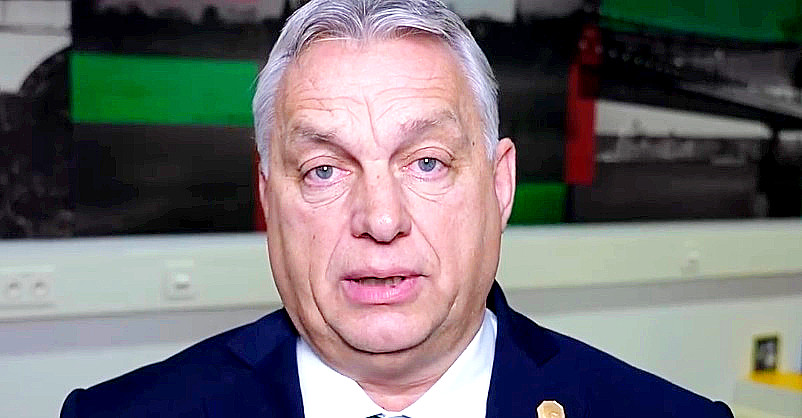 Orbán Viktor sötétkék zakóban, fehér ingben látható. Sápadt, rémült arccal a kamerába néz egy teremben.