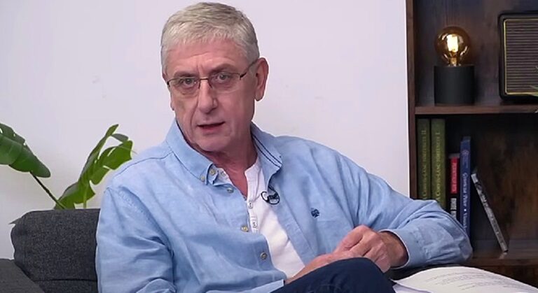 Gyurcsány Ferenc fehér felsőben, kék ingben egy kanapén beszél