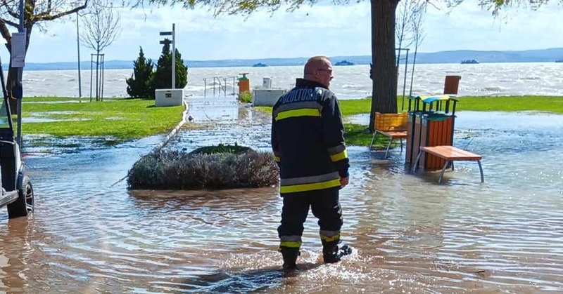 A fotón az látható, ahogy kiöntött a Balaton, és a tűzoltóság munkatársai éppen megpróbálják kiszivattyúzni a vizet a partról.