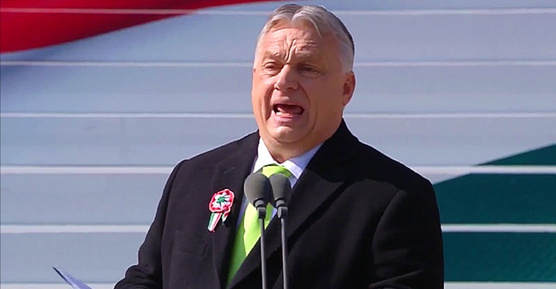 Orbán Viktor március 15-én, fekete öltönyben, fehér ingben, a zöld nyakkendőben a mikrofon előtt