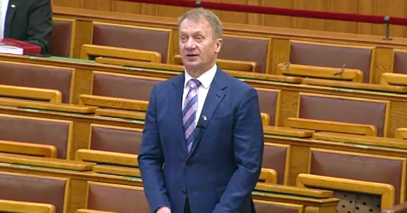 Varju László a parlamentben, sötétkék öltönyben, fehér ingben, csíkos nyakkendőben