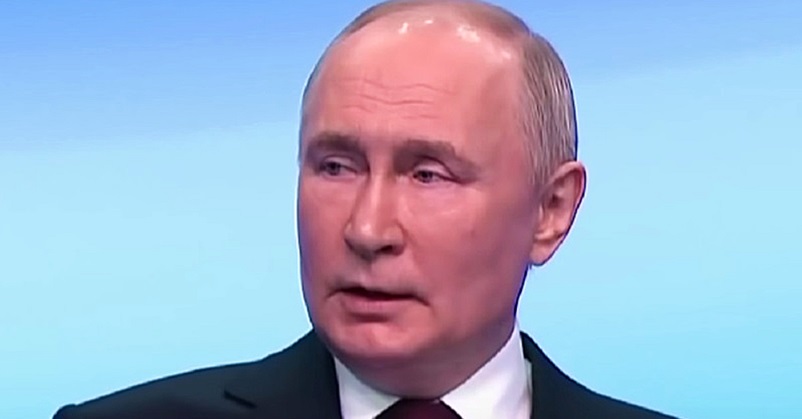 Vlagyimir Putyin fekete öltönyben, fehér ingben beszél