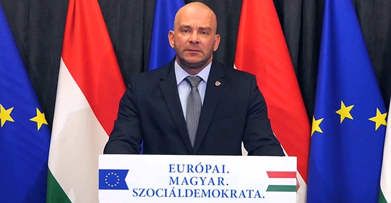 Mustó Géza, magyar zászló, EU-s zászló, fekete öltöny, kék ing, lila nyakkendő