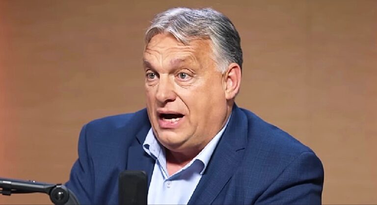 Orbán Viktor, interjú, mikrofon, miniszterelnök, kormányfő, kék zakó, öltöny, magyarázkodik barna háttér előtt őszülő hajjal világoskék ingben nyakkendő nélkül