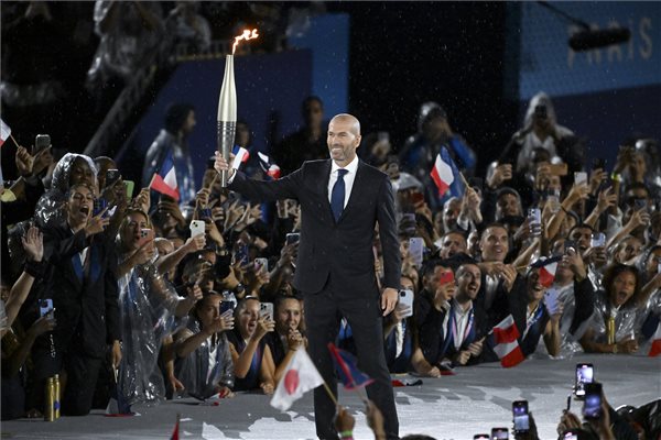 Zinédine Zidane korábbi francia válogatott labdarúgó viszi az olimpiai lángot a 2024-es párizsi nyári olimpia megnyitóünnepségén 2024. július 26-án. MTI/Czeglédi Zsolt