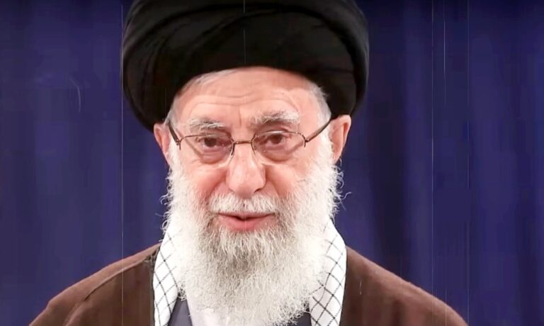 Ali Hamenei fekete turbánban, ősz szakállal, szemüvegben néz a kamerába.