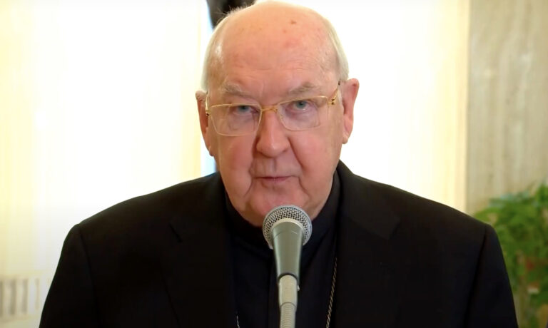 Kevin Joseph Farrell fekete reverendában egy mikrofonba beszél