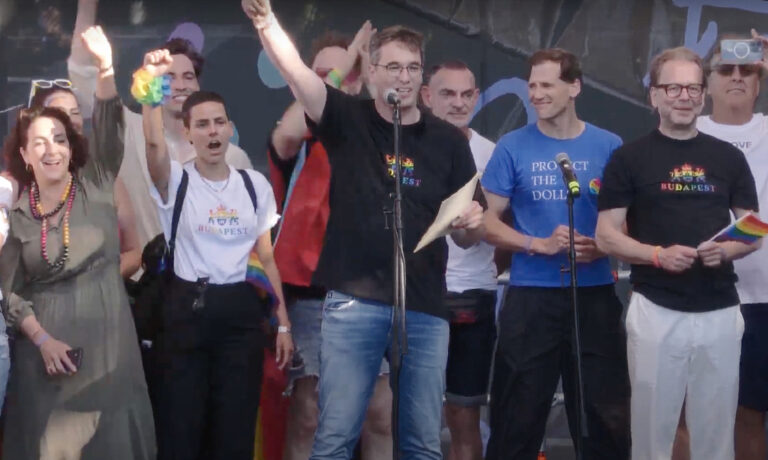 Karácsony Gergely a Budapest Pride színpadán fekete pólóban körülötte EP-képviselők