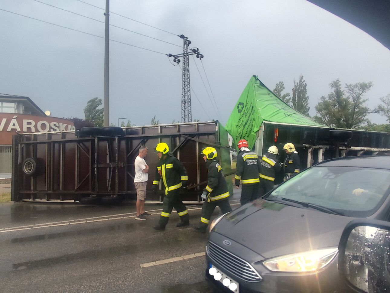 Felborult kamion Szentendrén, körülötte a tűzoltók dolgoznak