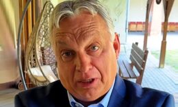 Orbán Viktor kék zakóban, világoskék ingben furcsán néz a kamerába.