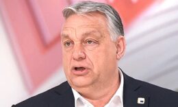 Orbán Viktor riadtan néz a kamerába. ÍFekete zakóban, fehér ingben van, haja ősz és rendezetlen.