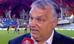 Orbán Viktor kék zakóban, fehér ingben, ősz hajjal, furcsa tekintettel az M4 Sport csatorna mikrofonjába beszél a felcsúti Pancho Arénában.